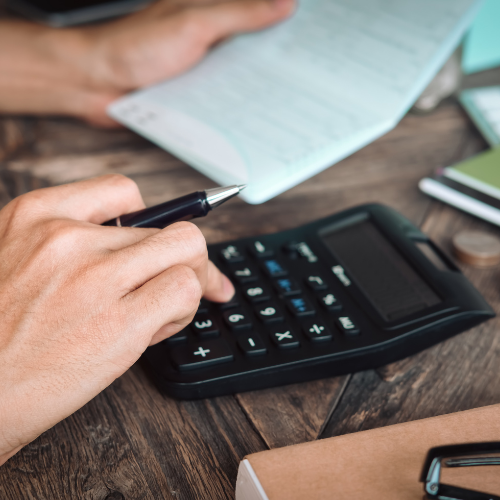 Imagen mano calculadora, bolígrafo y papeles, Ley de Segunda Oportunidad